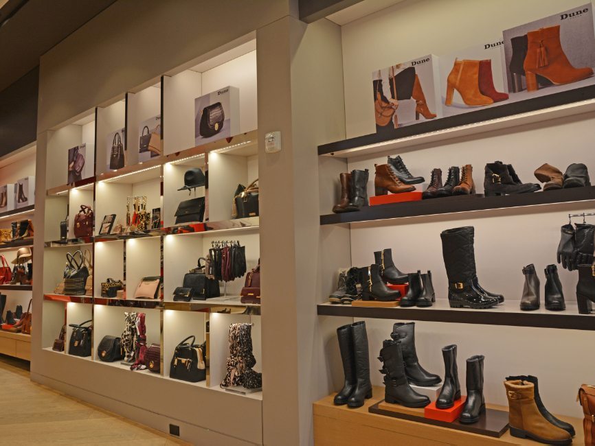 gallery image of custom retail interior project featuring custom LED illuminated shoe walls and handbag walls for Dune of London by Visual Millwork