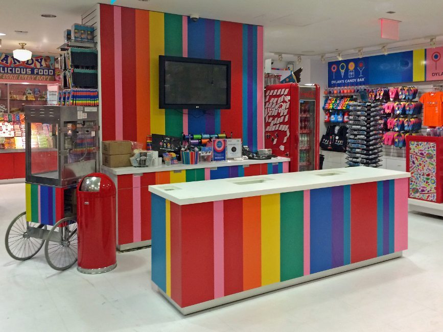 gallery image of custom retail interior finishes and components project featuring custom designed striped formica cash wrap for Dylan's Candy Bar in New York City by Visual Millwork