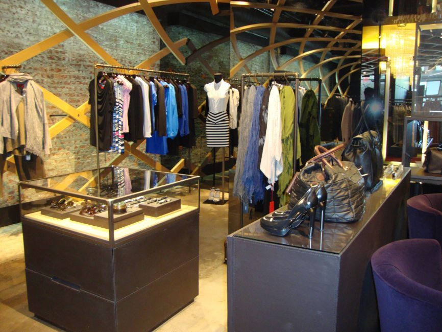 gallery image of custom retail interior clothing store featuring custom secure showcase, custom clothing rack, custom counter display, custom scarf display, and custom seating for Hugo Boss by Visual Millwork