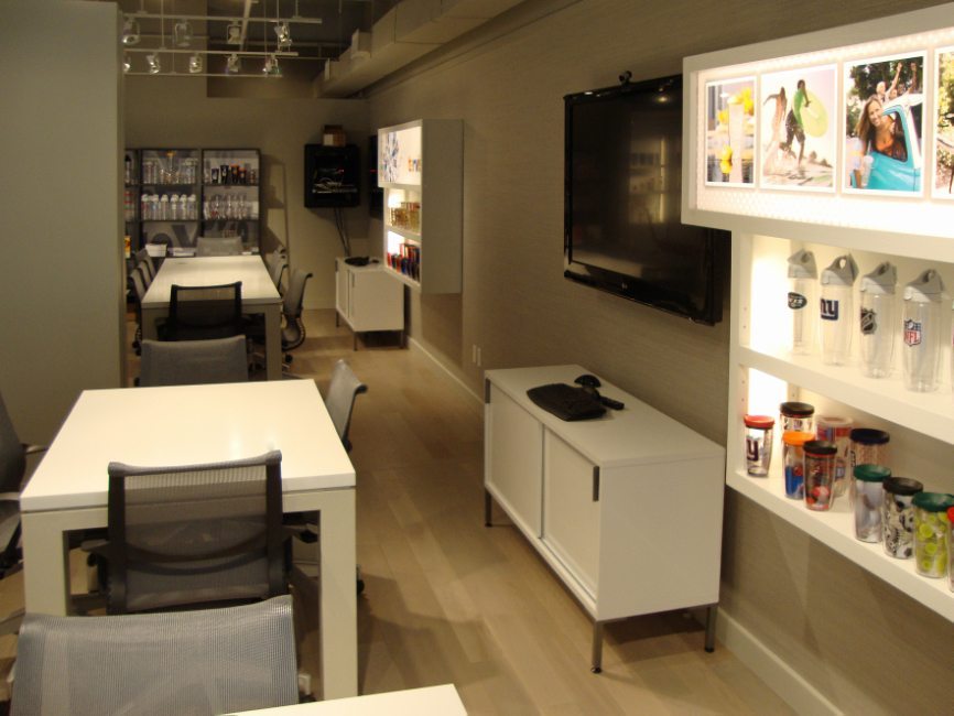 image of custom corporate interior project for Tervis Design Center featuring custom work tables, custom base cabinets, and custom illuminated walls displays and cabinets by Visual Millwork