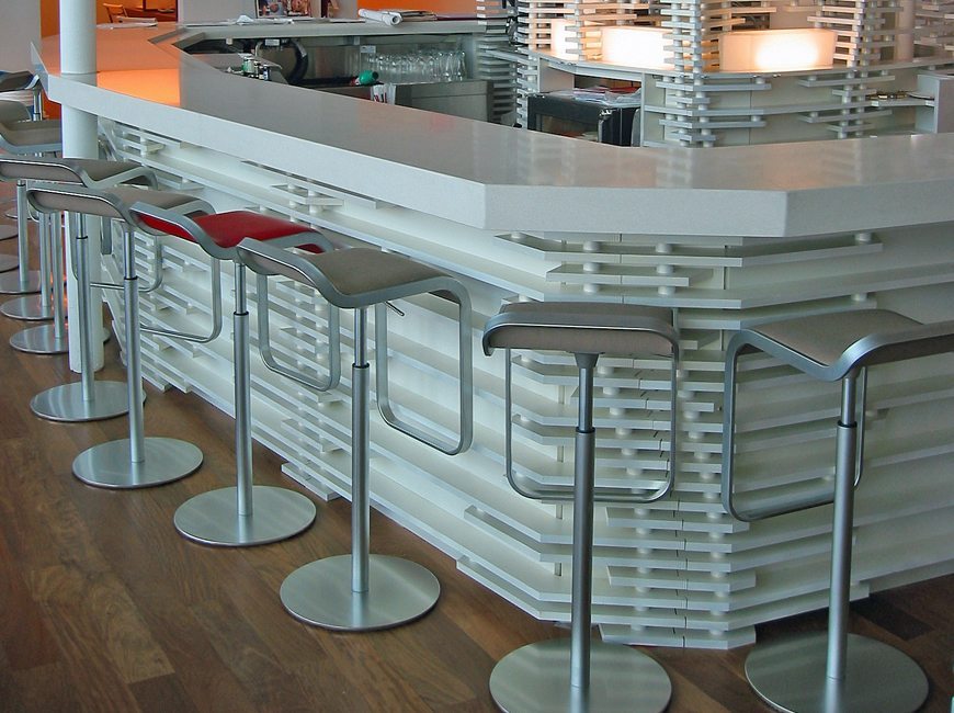 image of commercial interior project featuring custom bar with lattice woodwork and custom fabricated stools for Virgin Atlantic Lounge at JFK by Visual Millwork